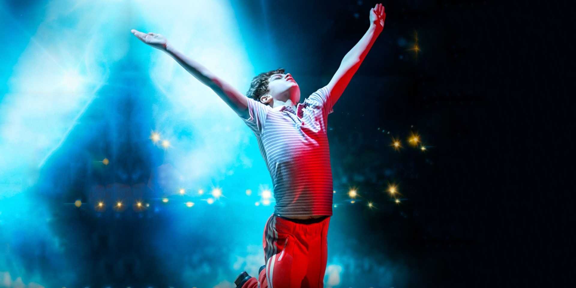 A promotional image shows Billy dancing in Billy Elliot: The Musical Live (2014)