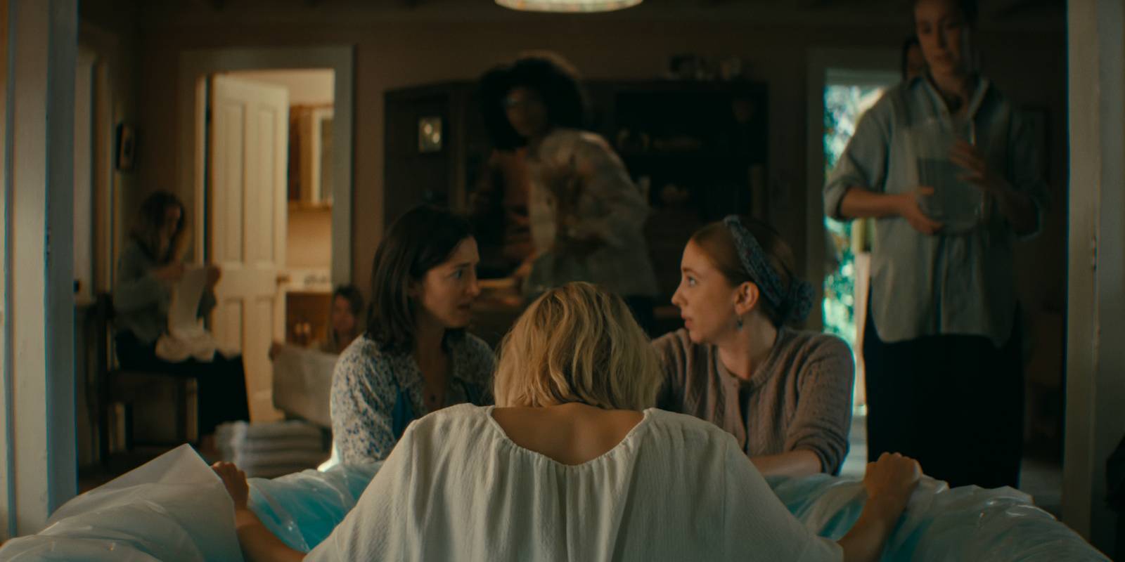 A group of women surround laura who's in labor in Wayward