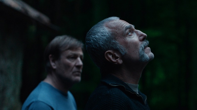 Anemone na Netflix: Retorno de Daniel Day-Lewis em 2026 Daniel Day-Lewis looks skyward as Ray Stoker while Sean Bean as Jem Stoker looks off into the distance in Anemone