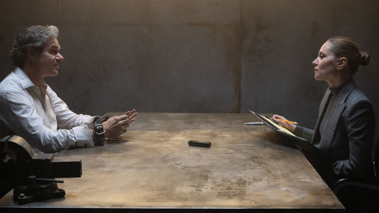 Tony Dalton as Jack Duquesne handcuffed and sitting at a table opposite of Margarita Levieva as Heather Glenn in Daredevil: Born Again