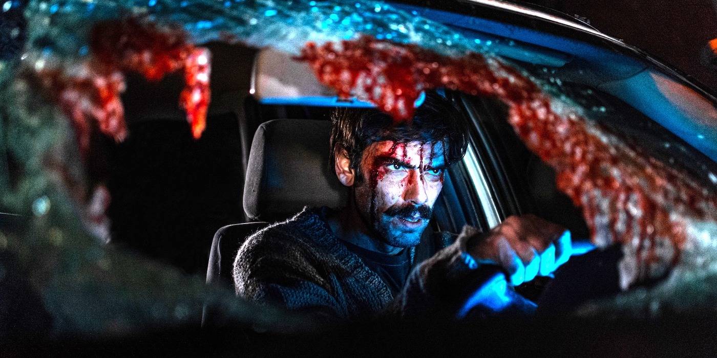 A bloodied Jimi is inside a car with the windshield broken in When Evil Lurks. 