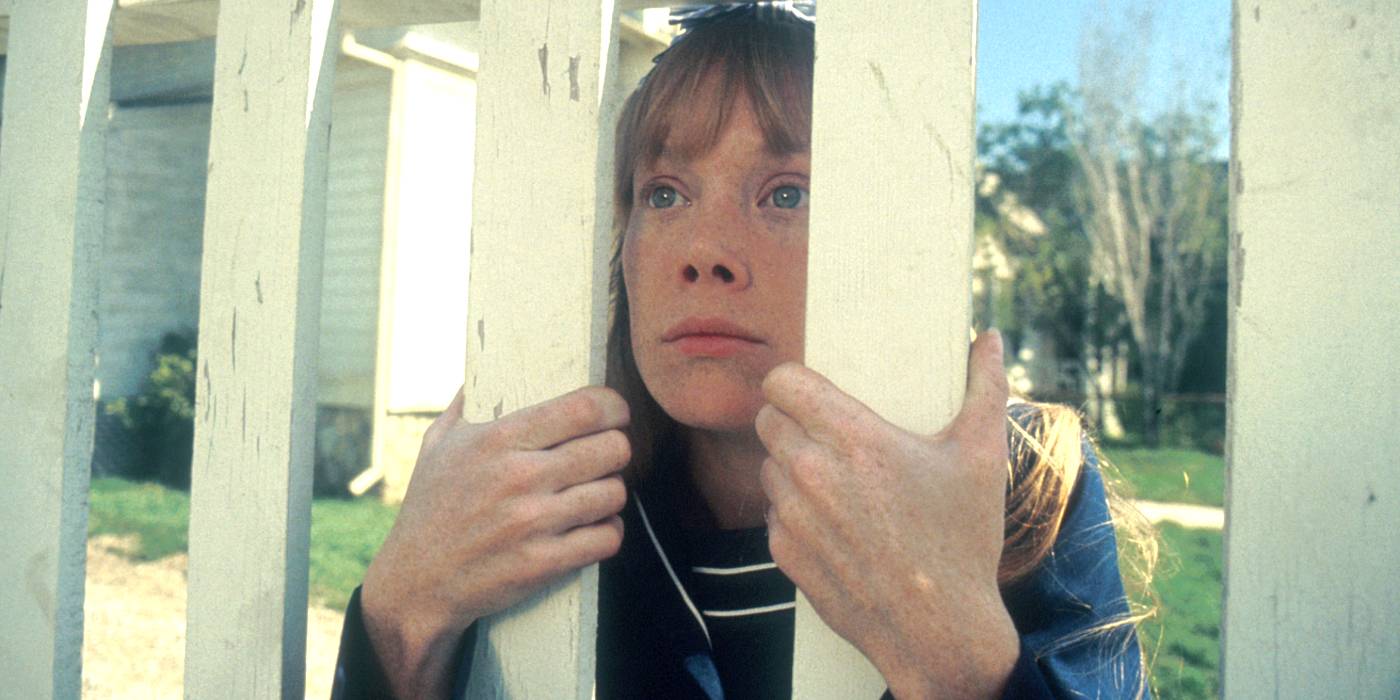 Carrie White looking through a fence in a dreamy sequence in Stephen King's Carrie 1976