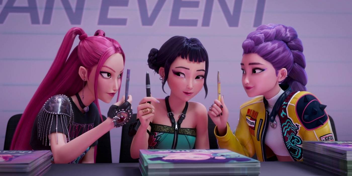 KPop Demon Hunters 2: Estreia nos cinemas pode render muito the three members HUNTR/X sitting together at the signing, holding up pens, in KPop Demon Hunters