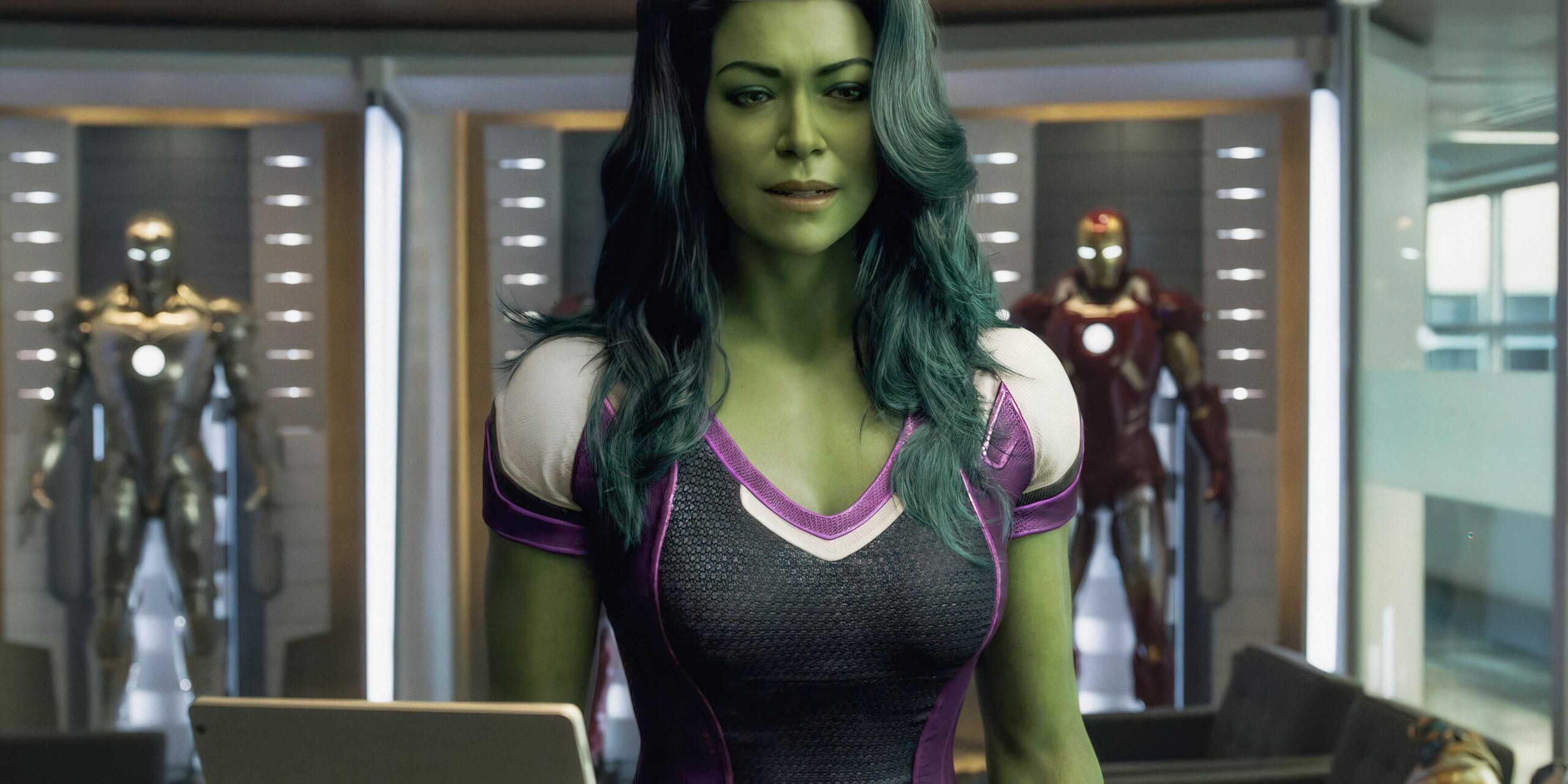 Tatiana Maslany como Jennifer Walters em cena de tribunal com visual verde de Mulher-Hulk