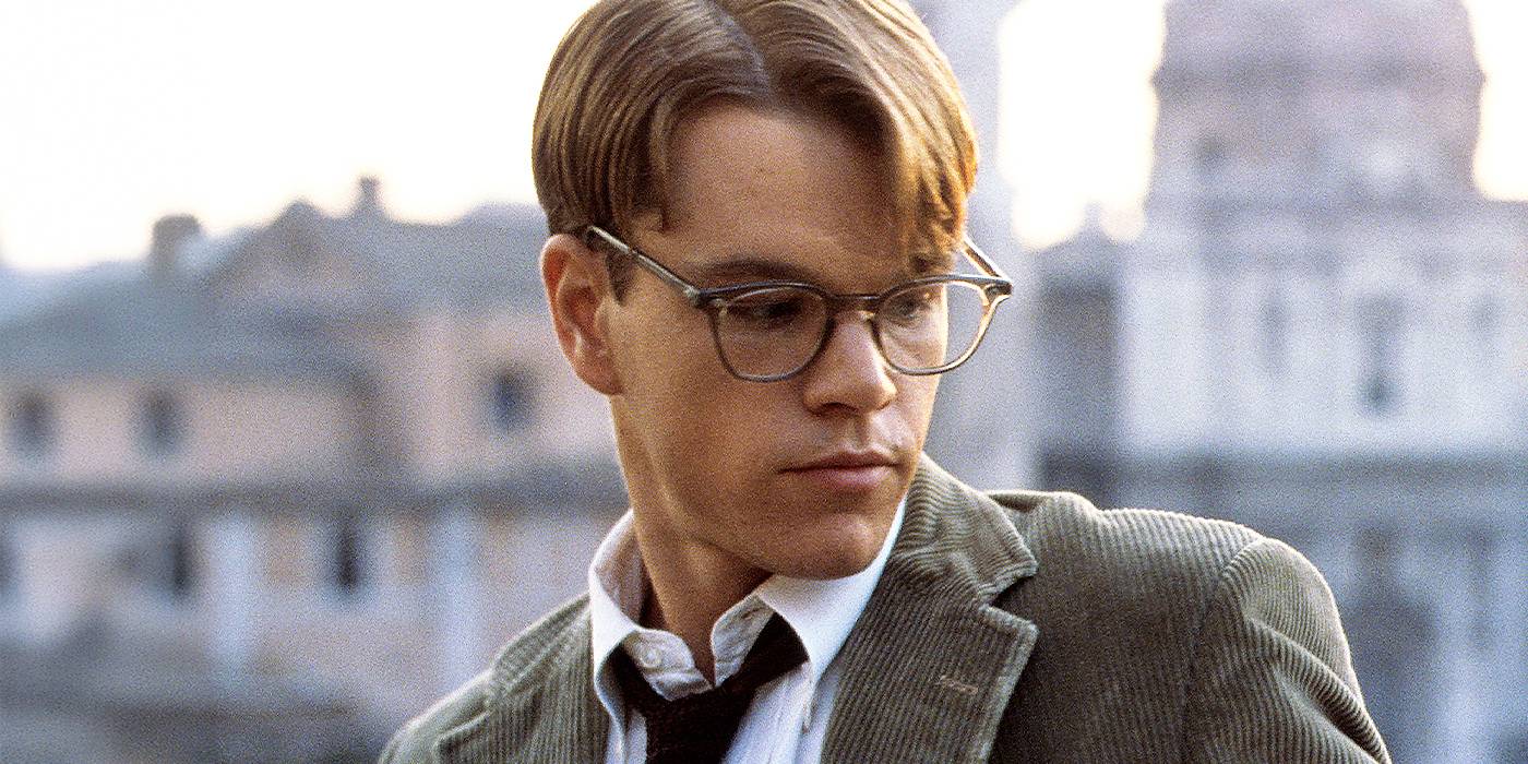 Thrillers psicológicos: 10 filmes com roteiro impecável Matt Damon usando óculos e olhando para o lado com prédios ao fundo em The Talented Mr. Ripley.