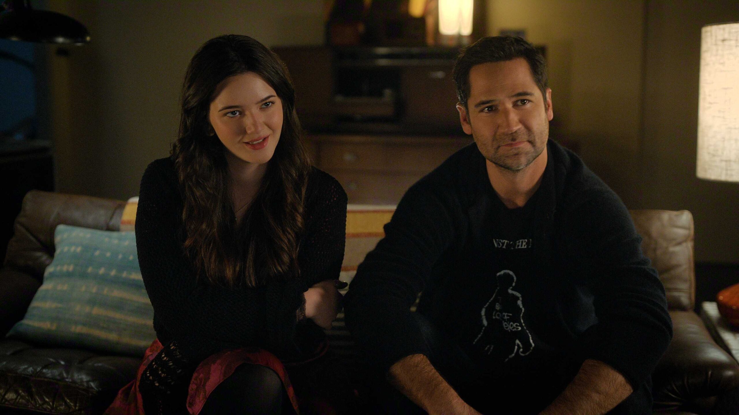 Hayley and Mickey sit together on the couch in The Lincoln Lawyer season 4 episode 10