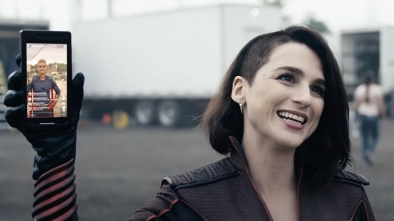 Stormfront segurando celular com transmissão ao vivo de Homelander na tela em <a href=