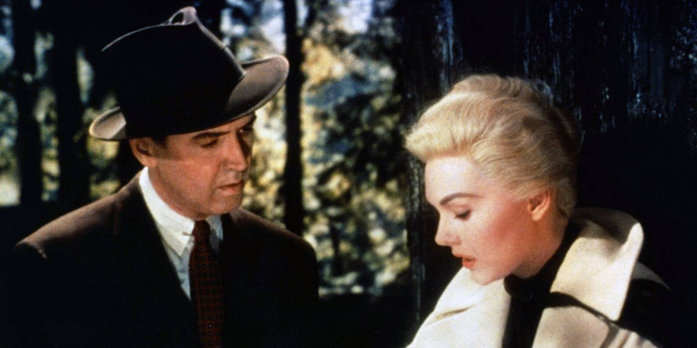 Thrillers psicológicos: 10 filmes com roteiro impecável Kim Novak e James Stewart como Madeline e John, em pé na floresta em Vertigo.